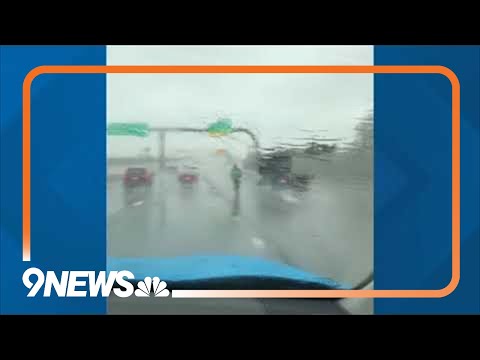People ride scooter on Colorado highway during rainstorm